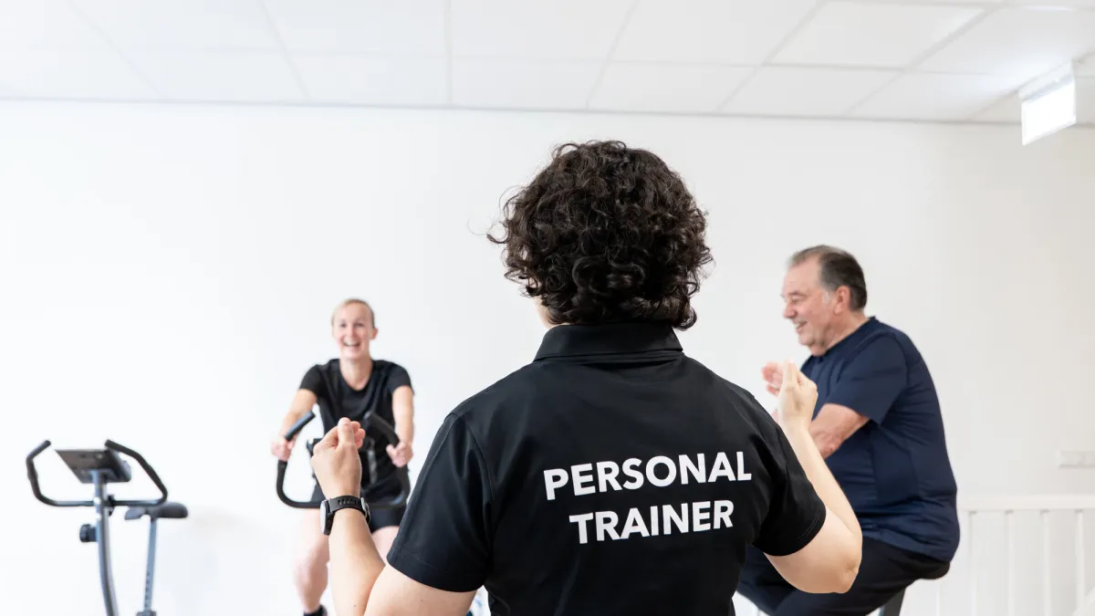 Twee klanten trainen naast elkaar in de Mpowher Huiskamer Gym terwijl Miriam hen begeleidt